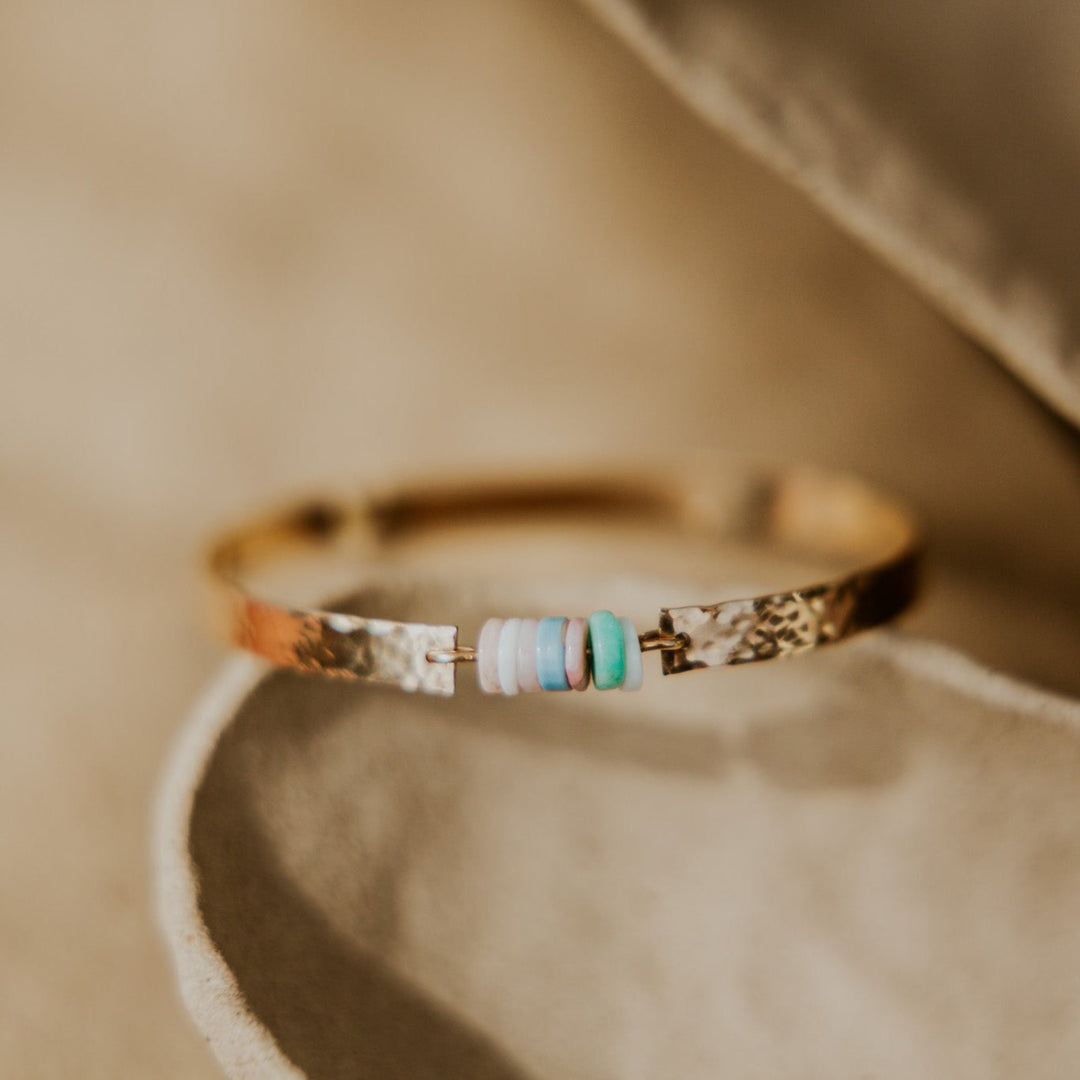 gold textured bangle with natural stones in the middle