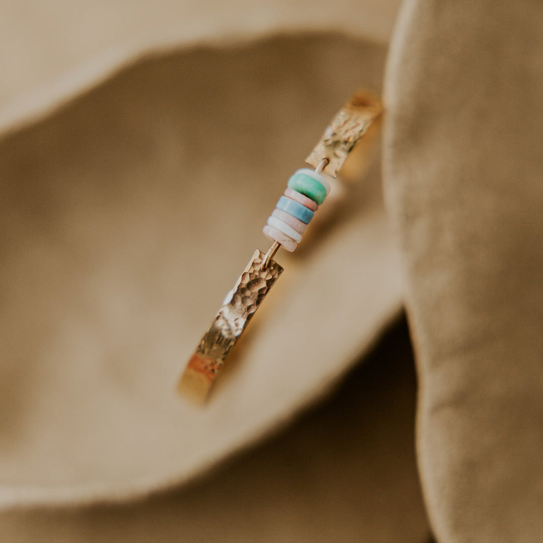 14k gold plated textured bangle with natural stones in the middle of bangle