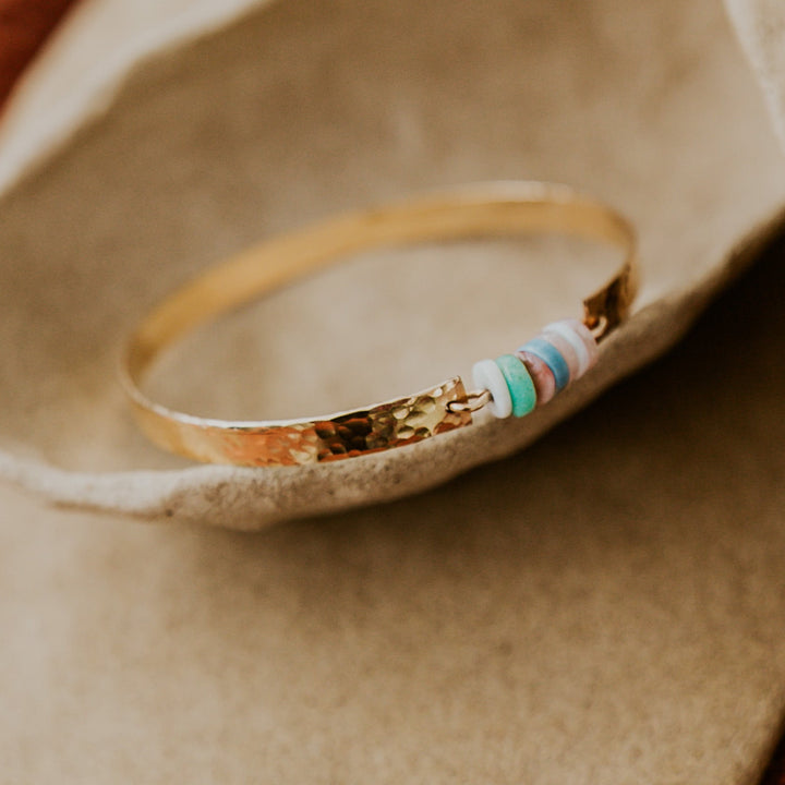 14k gold plated textured bangle with natural stones in the middle 