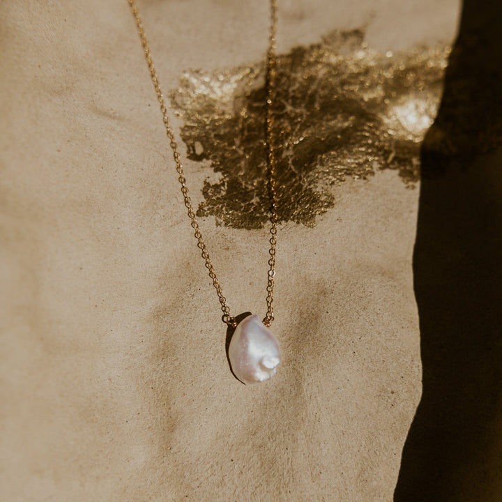 Pearl necklace on a textured beige background