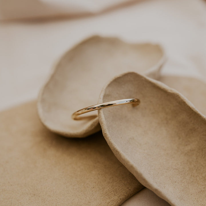Gold ring on a beige leaf-shaped jewelry dish