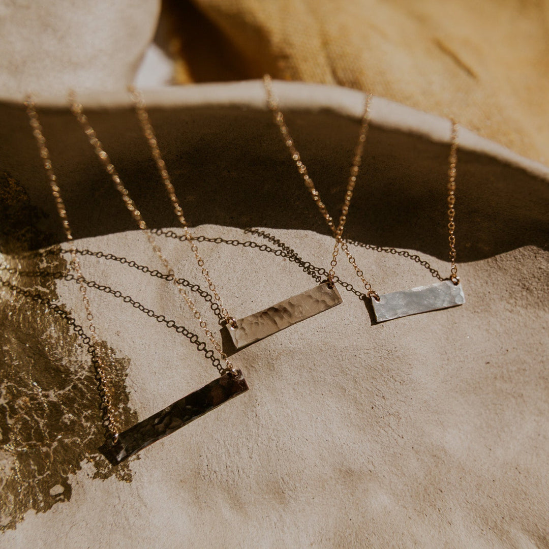 Necklace with rectangular pendants on a textured surface