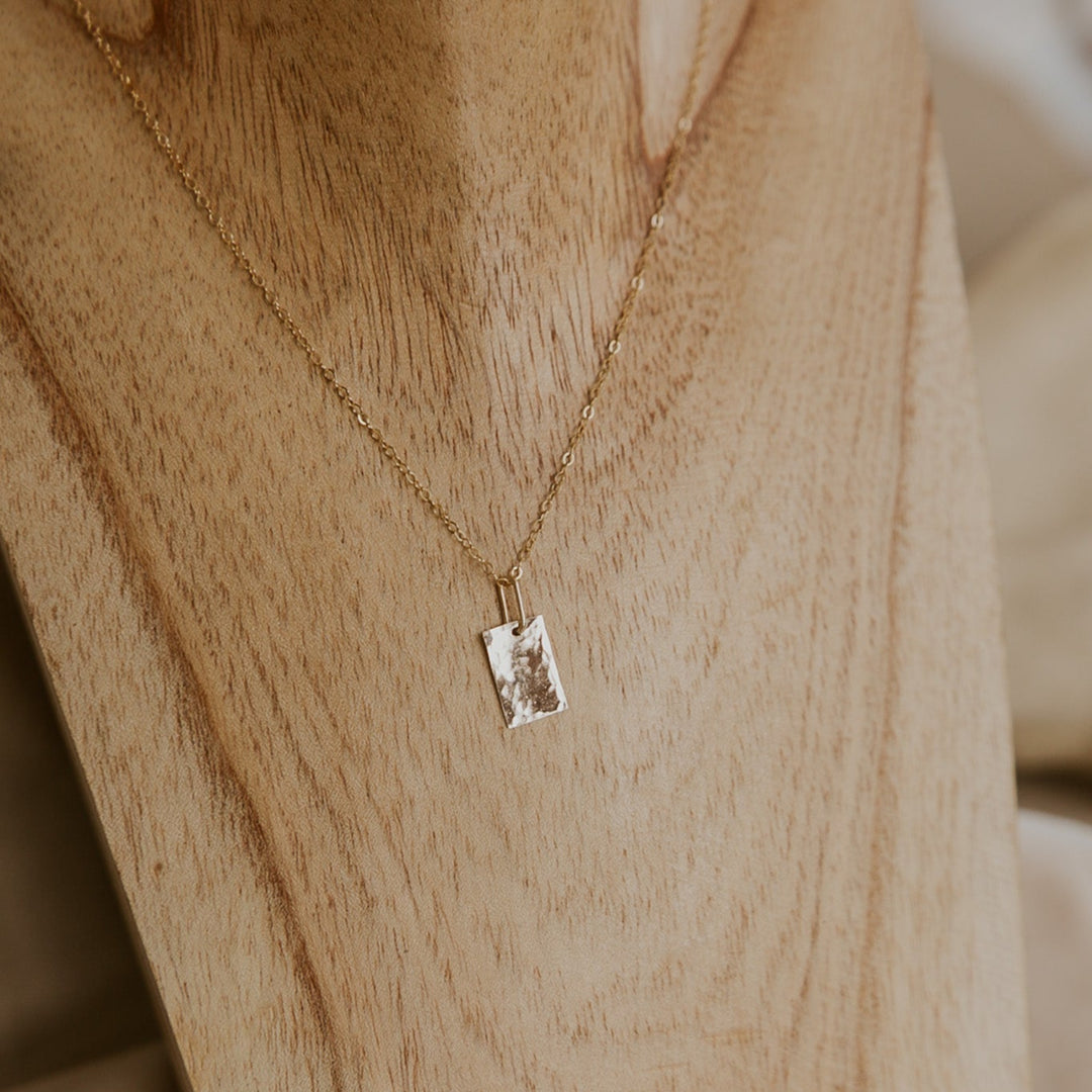 Necklace with a pendant on a mannequin wearing a beige garment