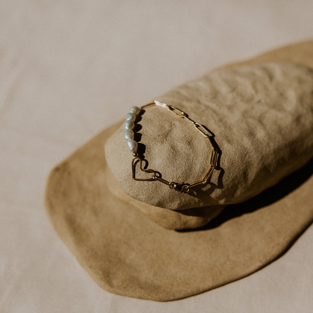 Round stone with a chain on a beige pillow