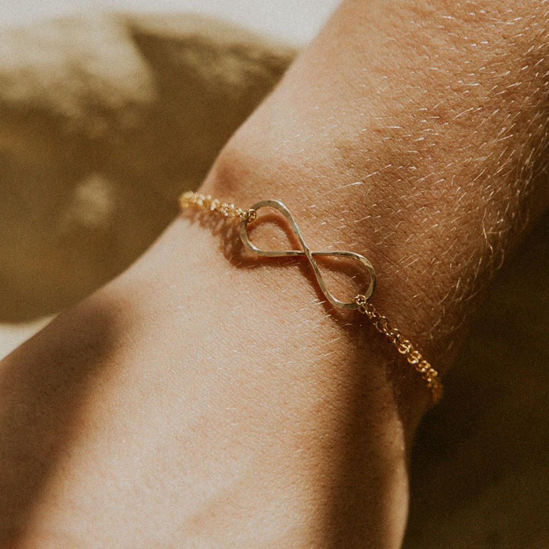 Gold bracelet on a wrist with a blurred background
