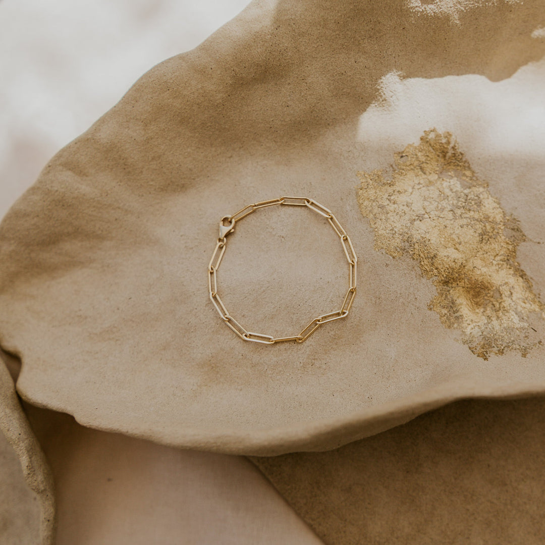 Gold bracelet on a textured stone surface