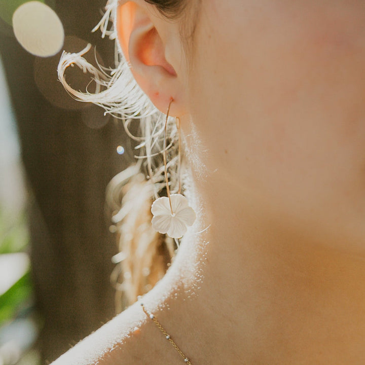 Close-up of a person wearing a delicate earring with a blurred background