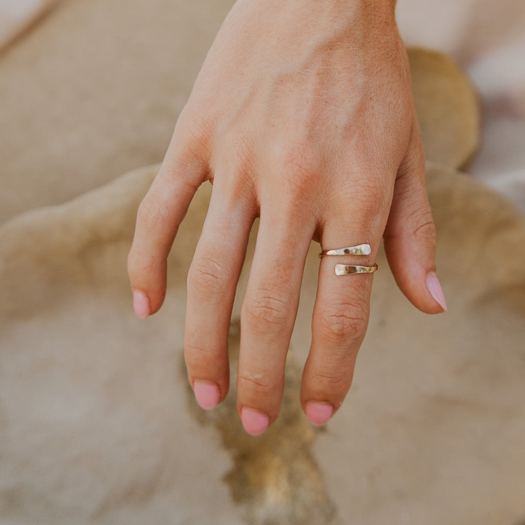 Hand with gold rings  on a blurred natural background