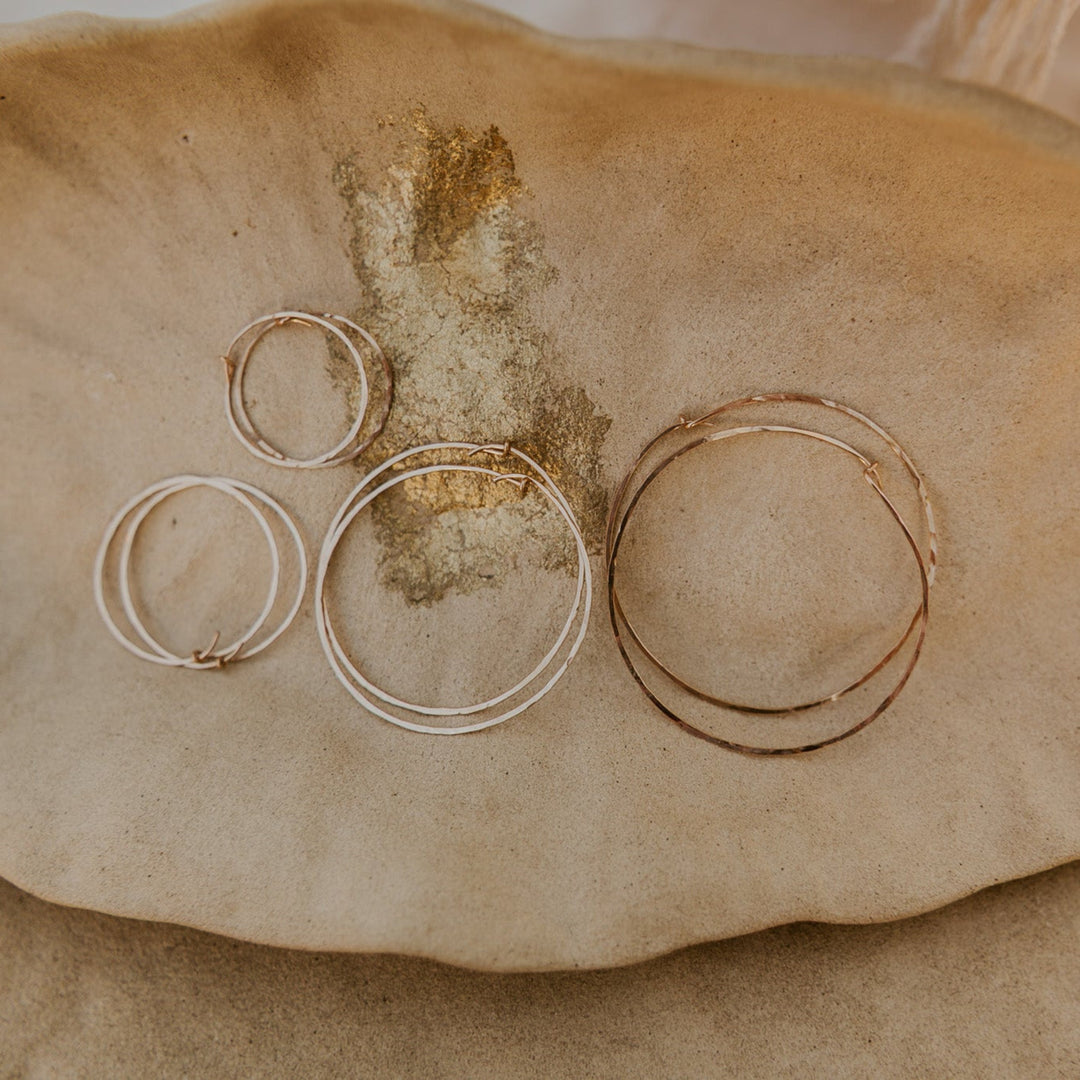 Gold rings on a textured beige surface