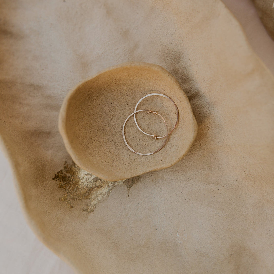 Gold ring on a textured beige surface