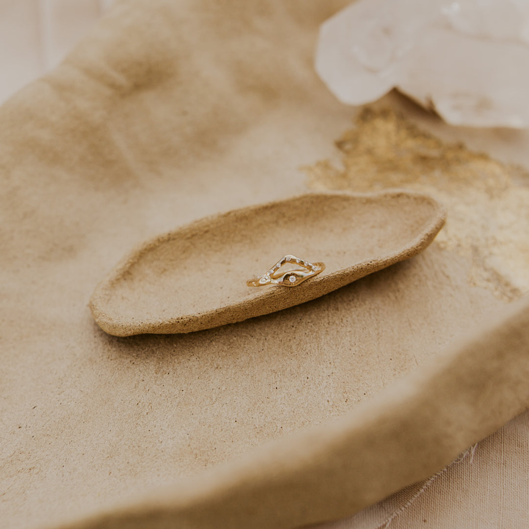 Gold ring on a textured beige surface