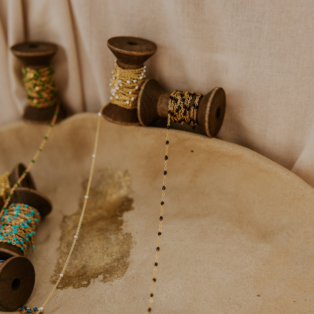 Spools of thread with decorative beads on a textured surface