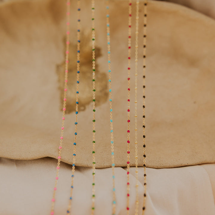 Colorful beaded necklaces on a beige surface