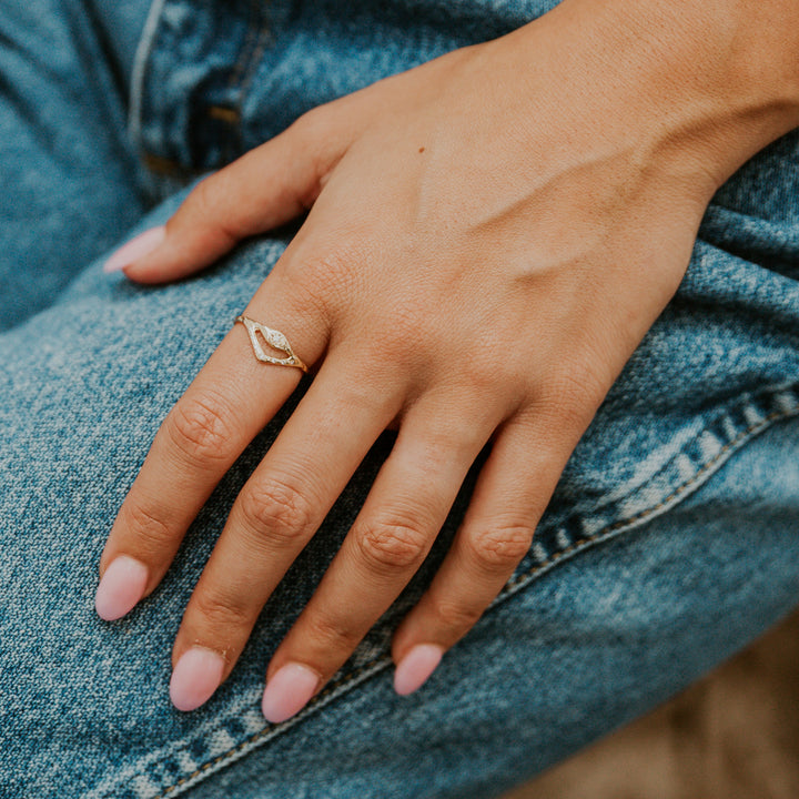 Hand with a gold ring on a denim background