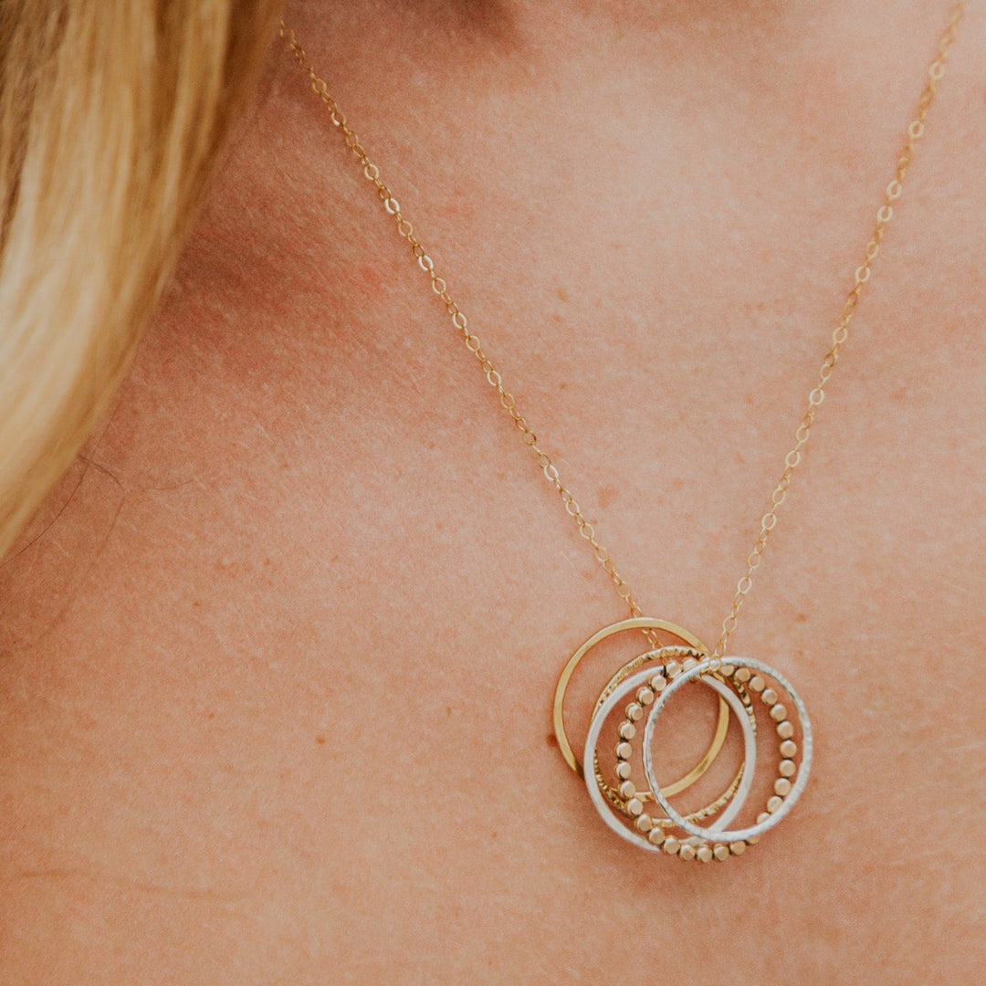 Gold necklace with interlocking rings on a person's neck