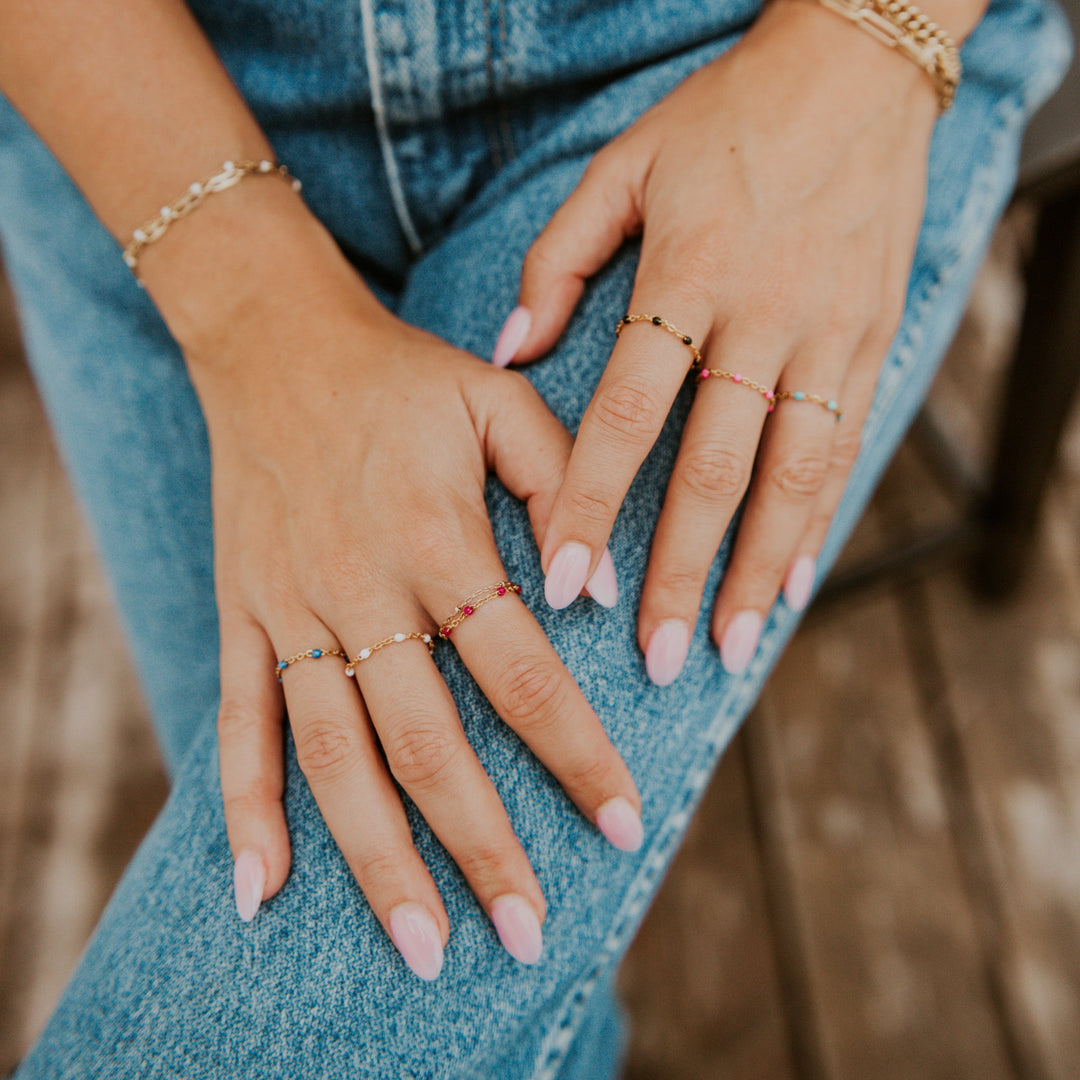 Close-up of hands with multiple rings on a denim background