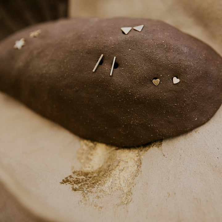 Brown fabric with various small jewelry items on a textured surface