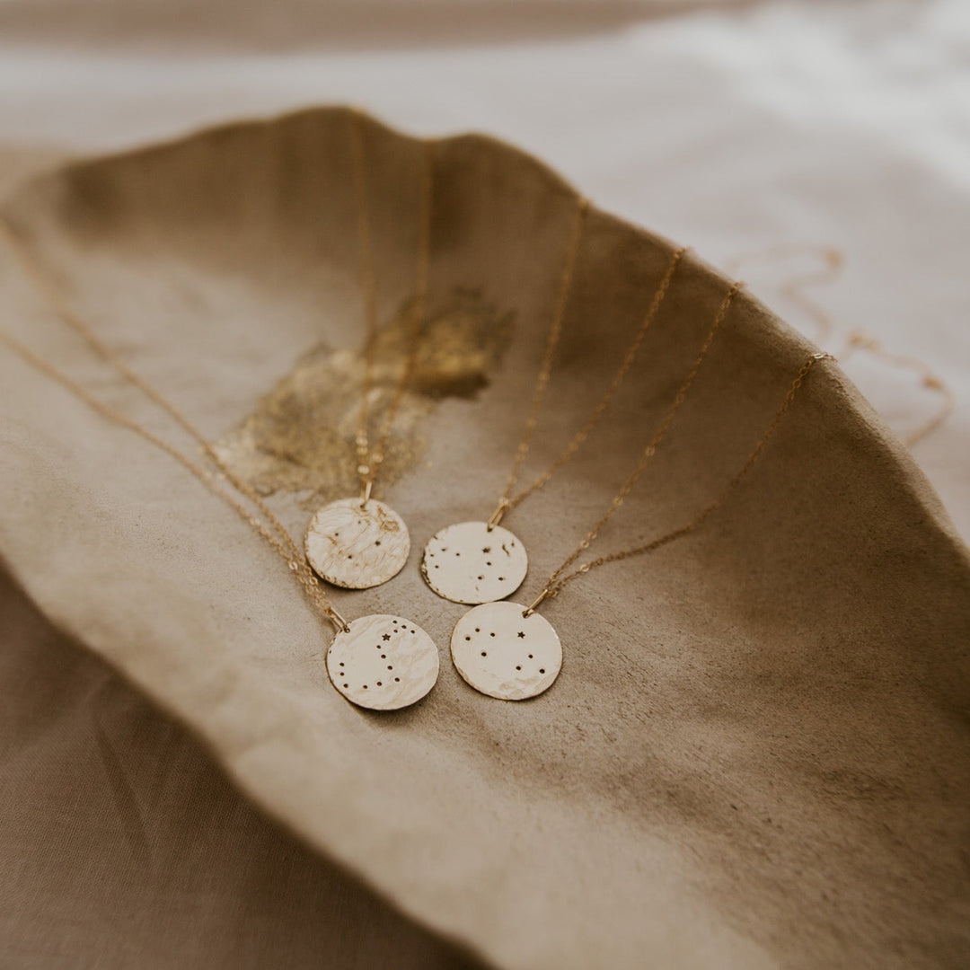 14k gold fill disc with stamped constellation pattern on it for birth month and horoscope