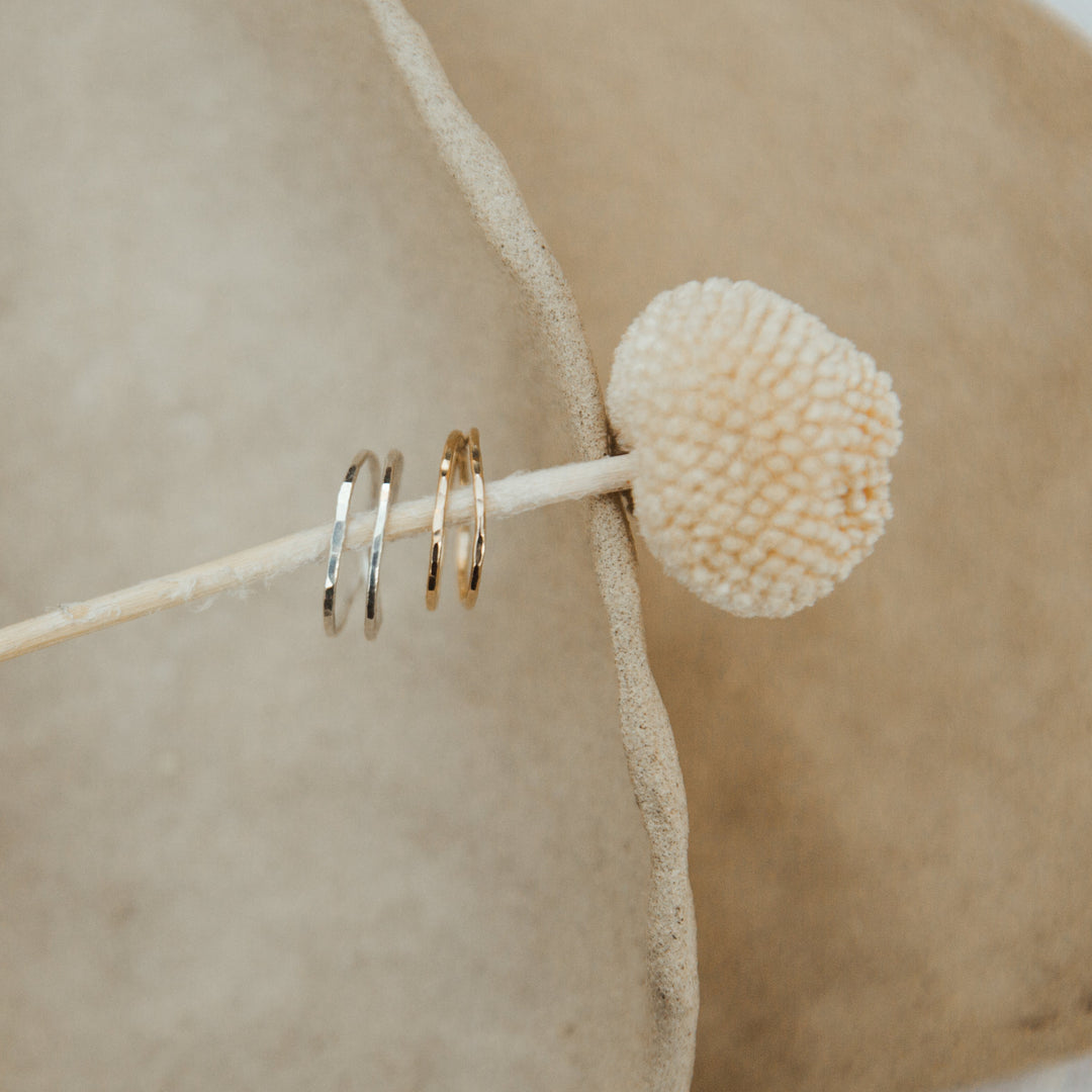 gold and silver double wrap rings styled  on a beige background
