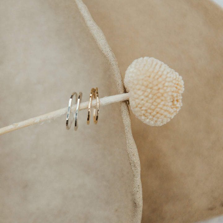 gold and silver double wrap rings styled  on a beige background