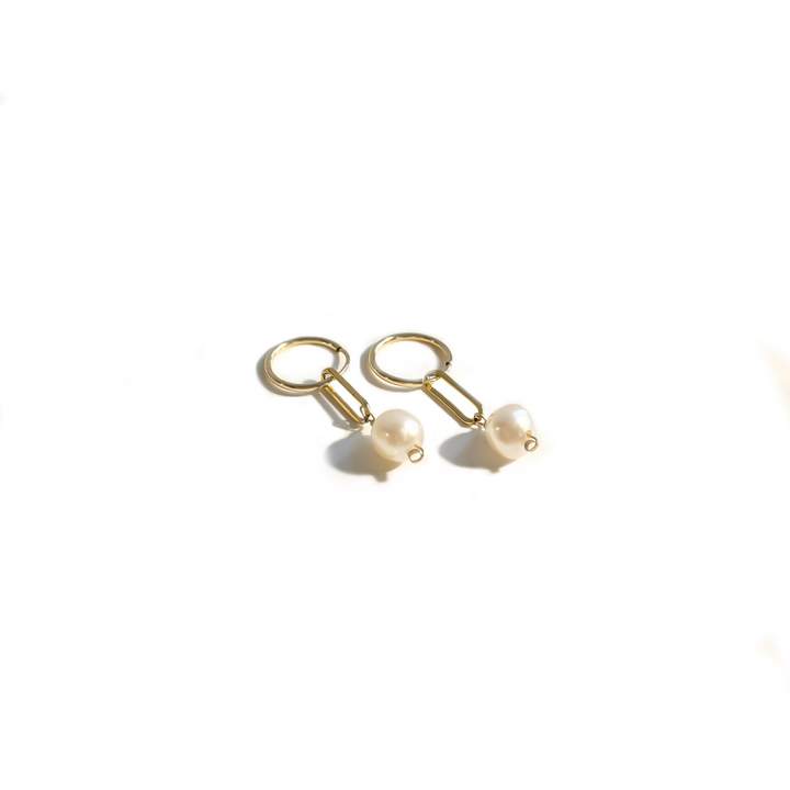 A pair of gold-filled hoop earrings with pearl dangles on a white background.