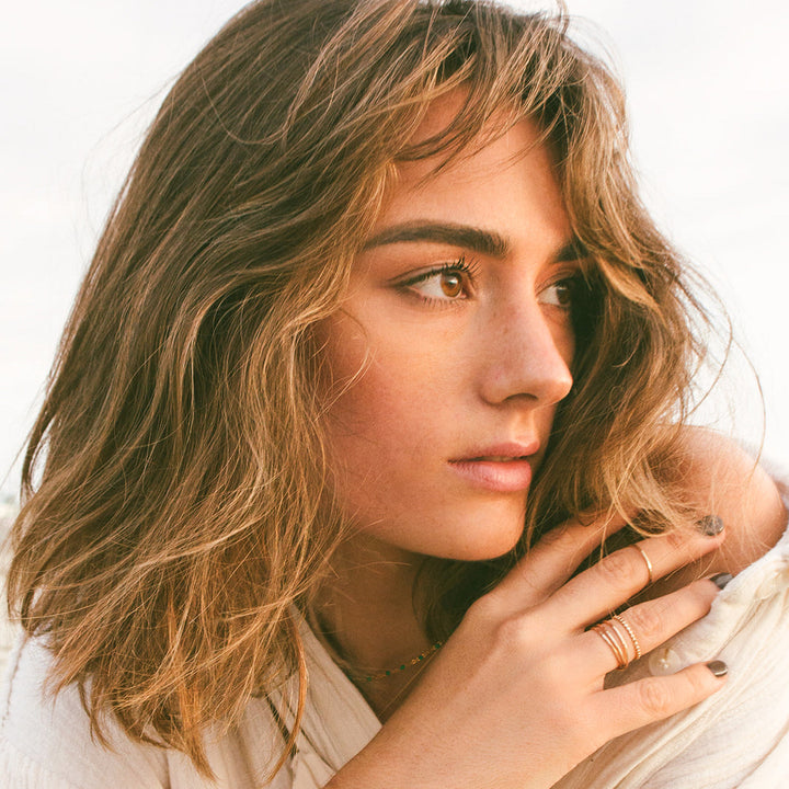 Woman wearing triple wrap gold ring 