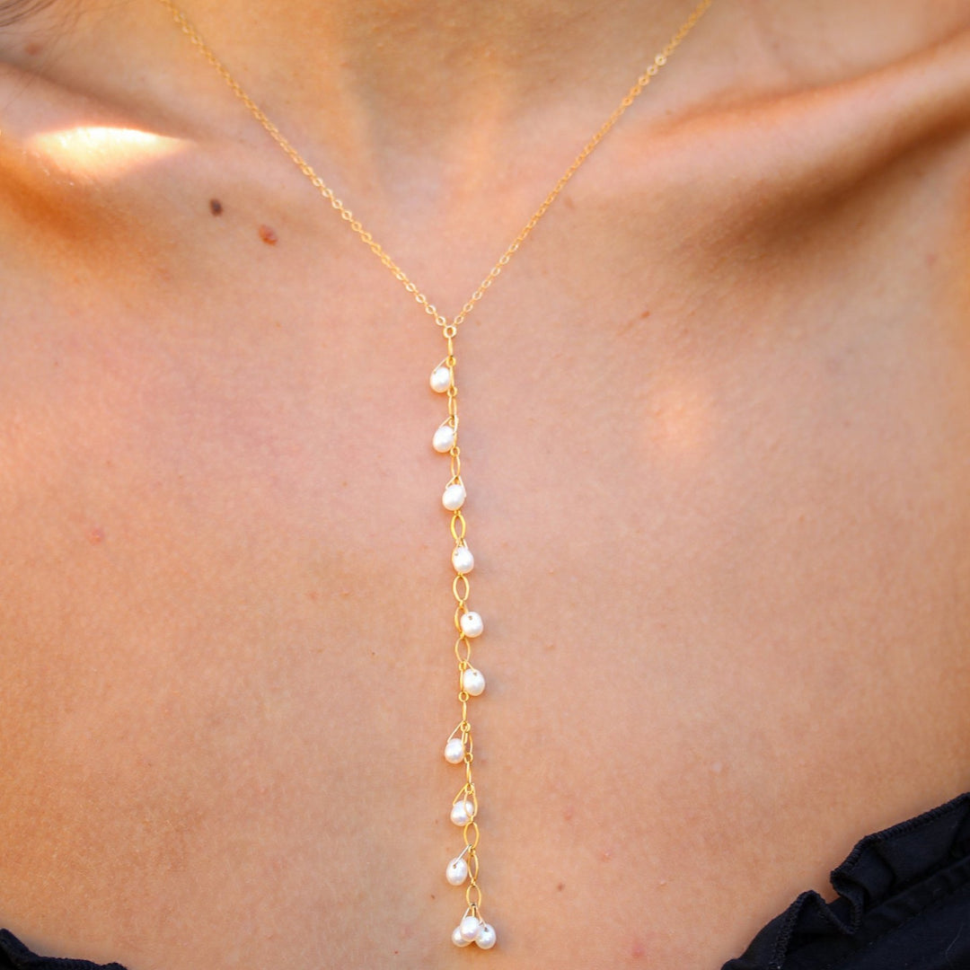 Close-up of the Celeste necklace on the neckline, freshwater pearls falling down a fine gold filled drop