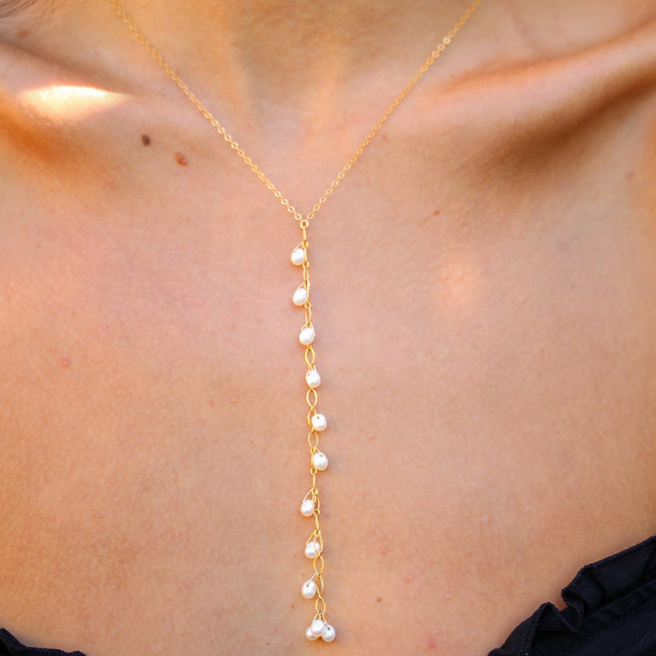 Close-up of the Celeste necklace on the neckline, freshwater pearls falling down a fine gold filled drop
