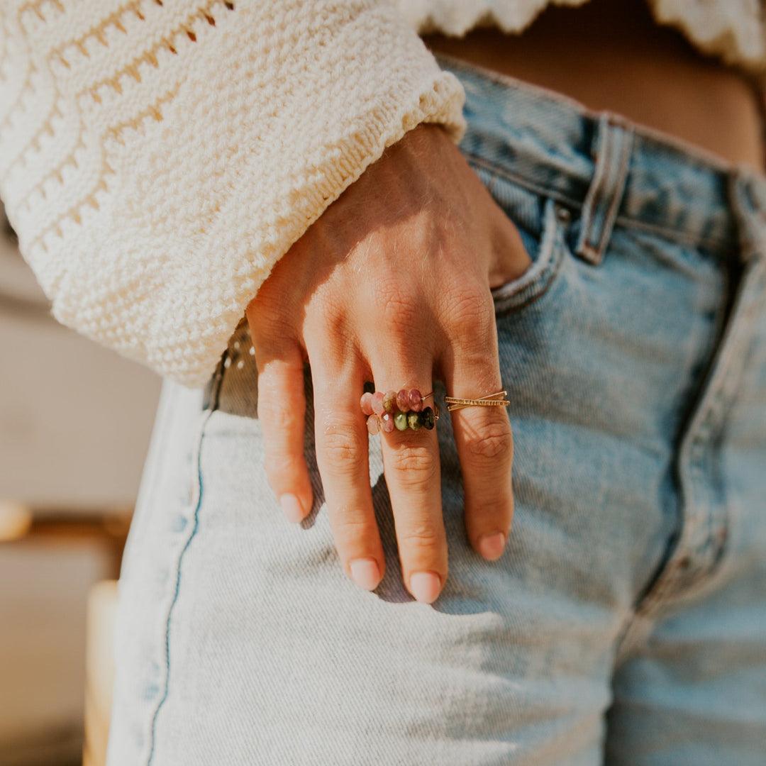 Emma gemstone ring from Teressa Lane Jewelry worn on a hand with light denim and a crochet top