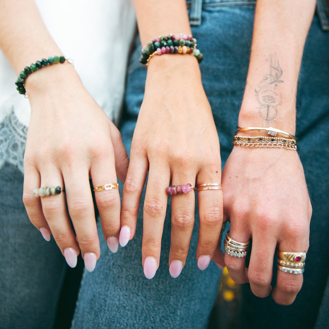 Emma gemstone ring showcased with colorful bracelets on stylish hands for a fashionable look