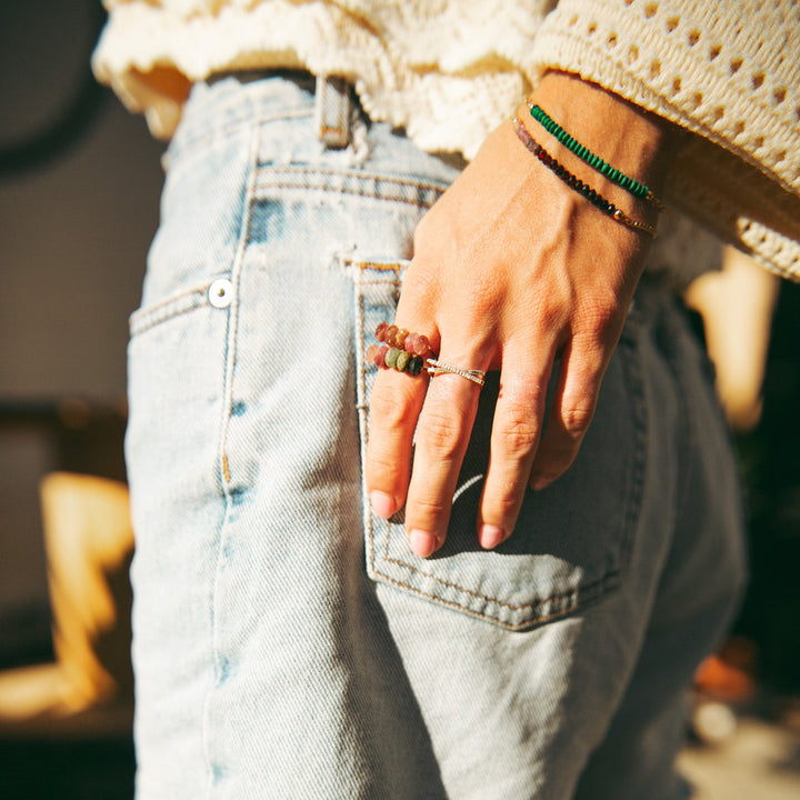 Close-up of a hand wearing the Teressa Lane Jewelry Emma gemstone ring with denim jeans
