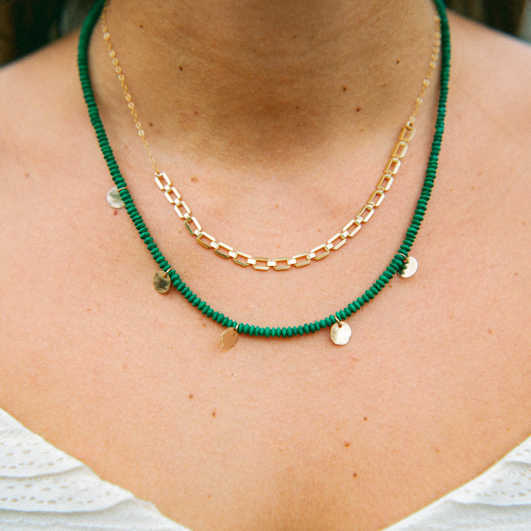Green beaded gold charm necklace layered with delicate gold chain for a stylish look