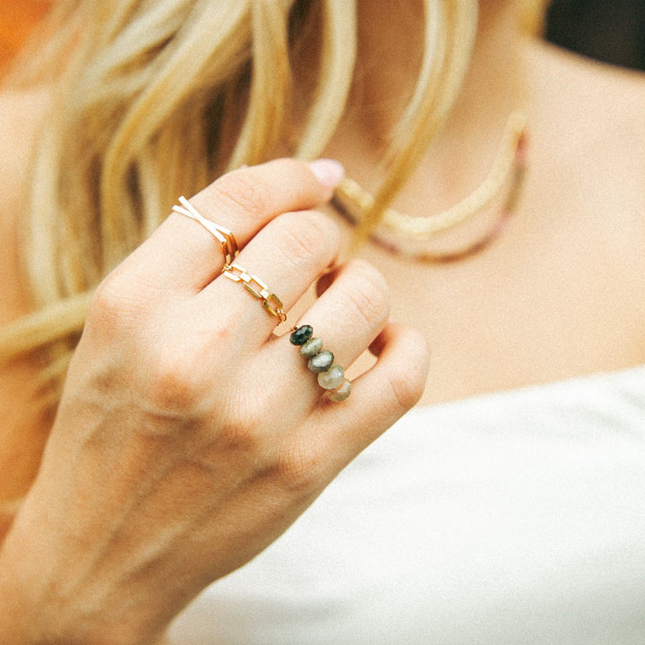 Stylish handmade jewelry Carlsbad featuring gold and gemstone rings worn on a woman's hand