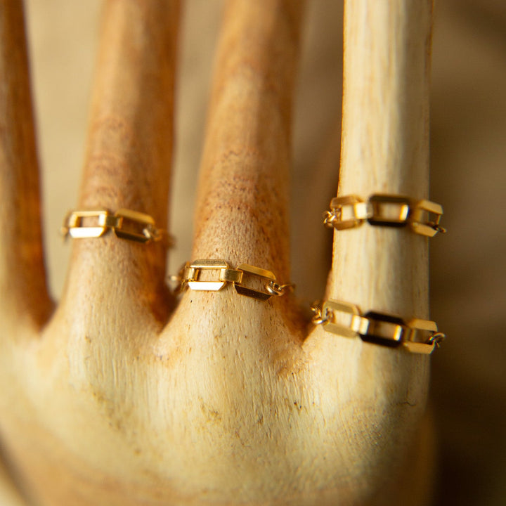 Set of gold Teressa Lane Jewelry rings displayed on a hand model, showcasing handmade jewelry Carlsbad