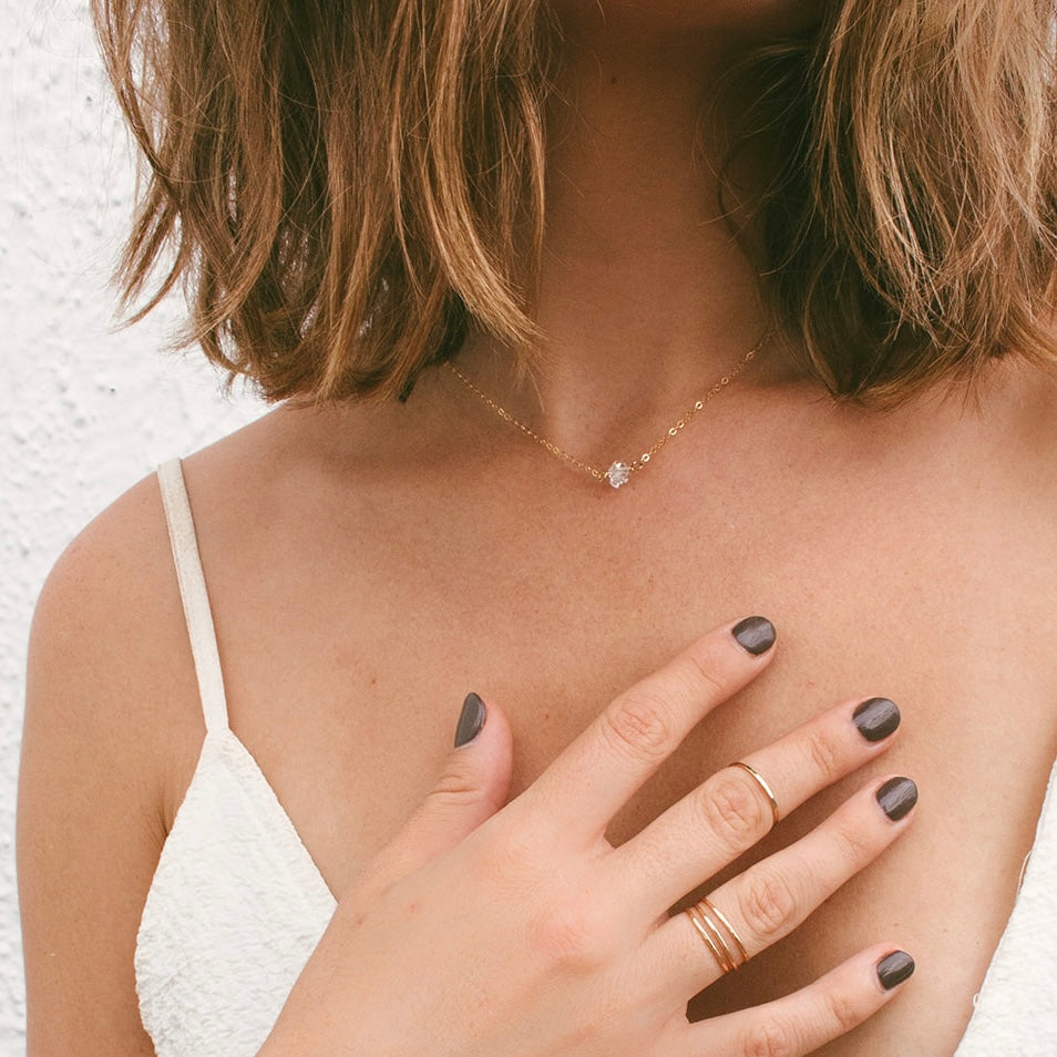 Teressa Lane Jewelry handmade stacking ring on woman's hand with neutral nail polish and white top