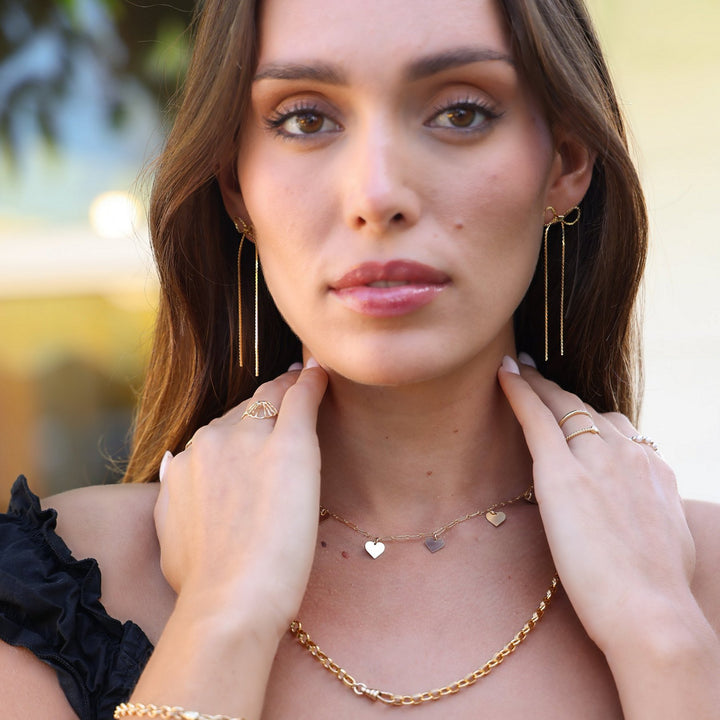 Model with hands at her neck wearing the Heart necklace layered over the Vivienne gold filled chain necklace
