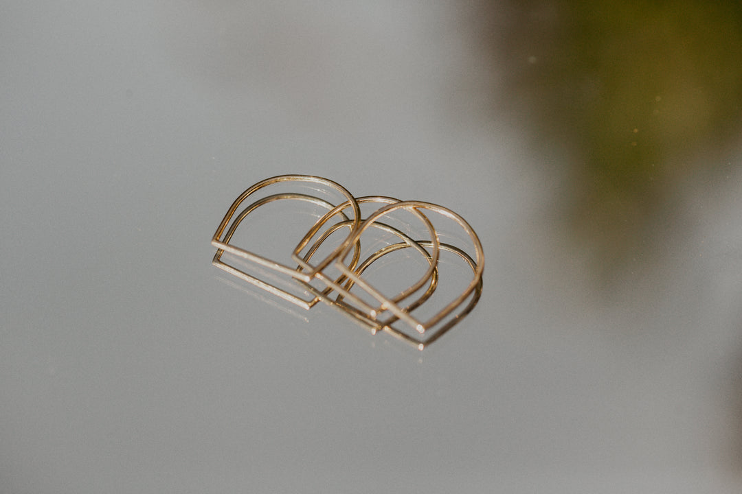 Gold hand shaped rings on a blurred background
