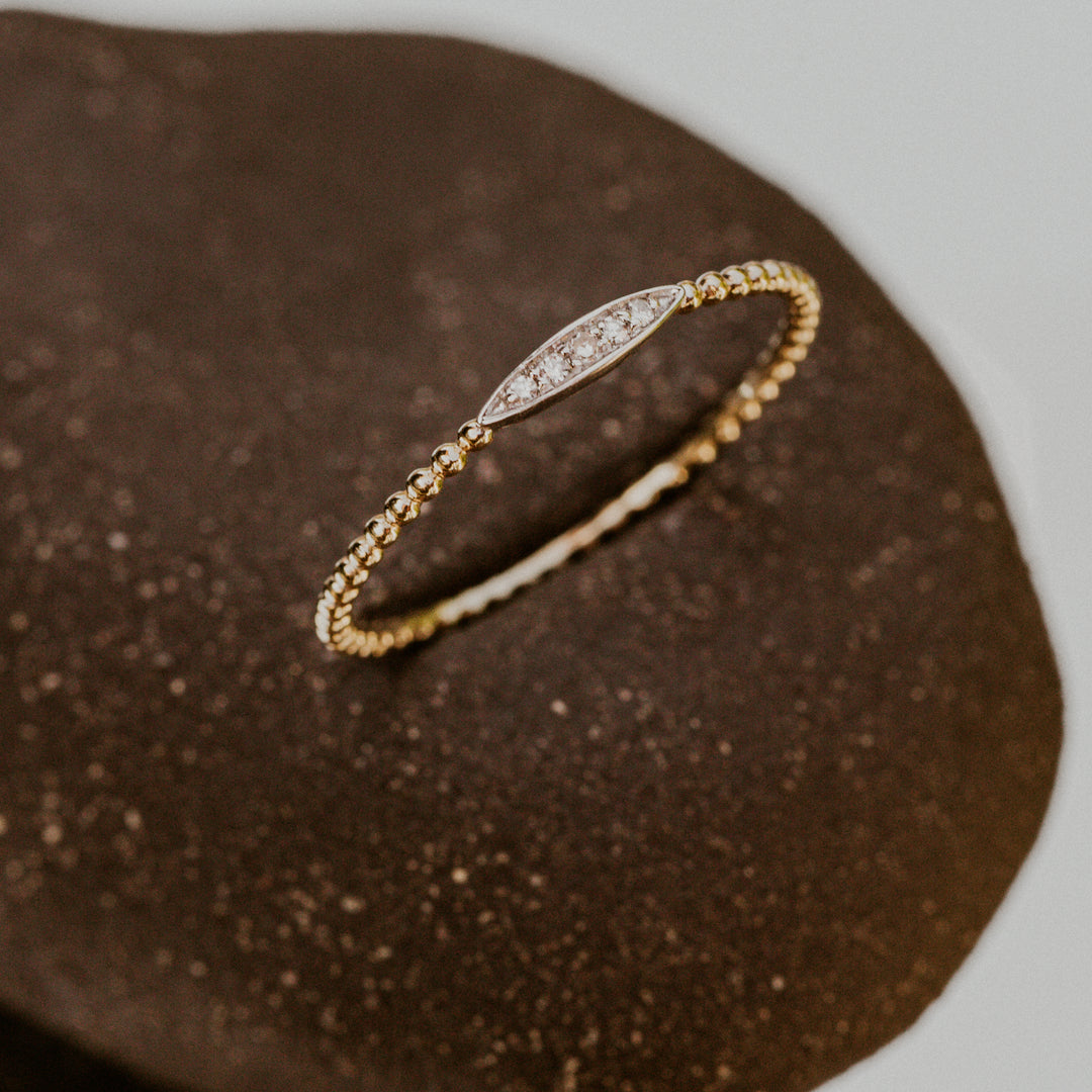 14k gold band with oval design on band filled with diamonds