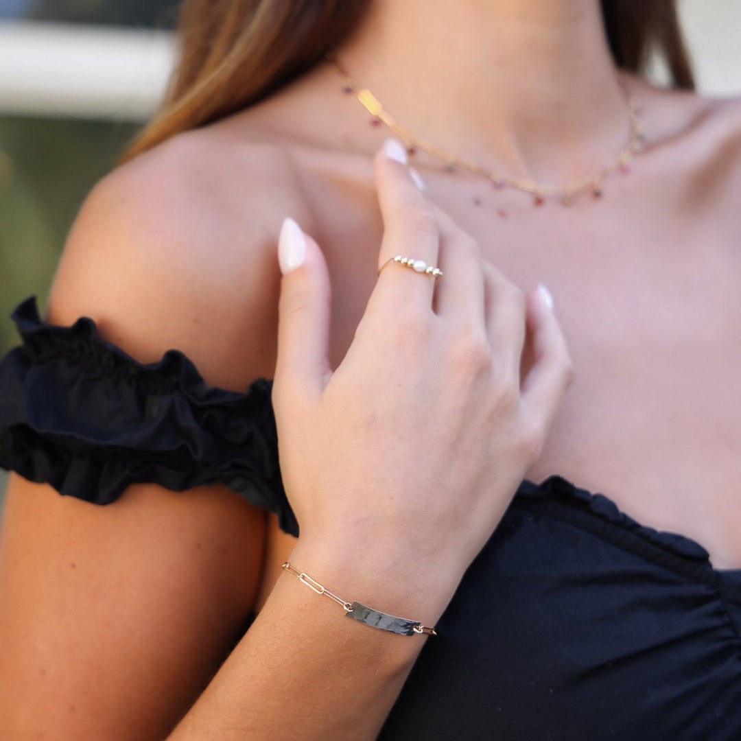 Close-up of the Kim hammered bar bracelet with the Juliette spinel necklace worn above
