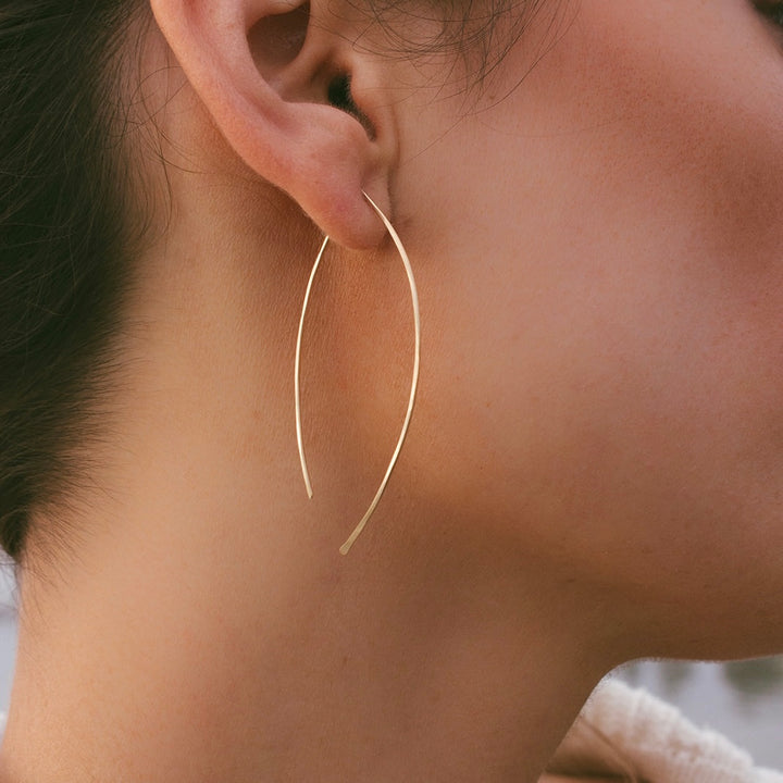 Teressa Lane Jewelry gold leaf threader earrings worn on ear with delicate curved design