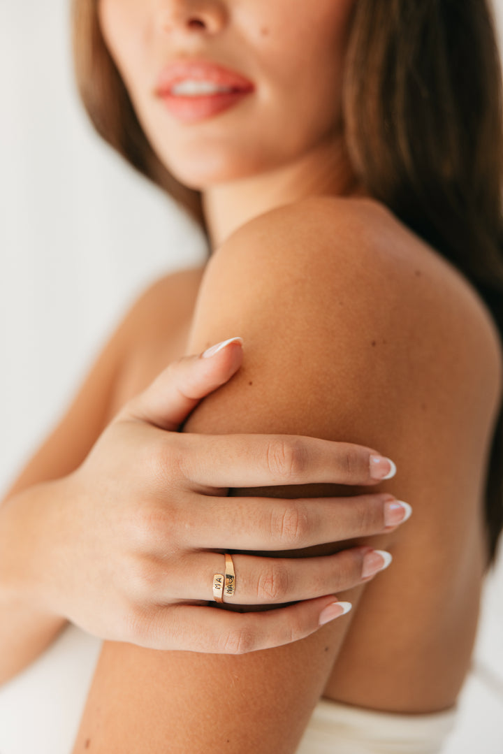 Woman wearing a gold adjustable wrap ring on her hand with a blurred background