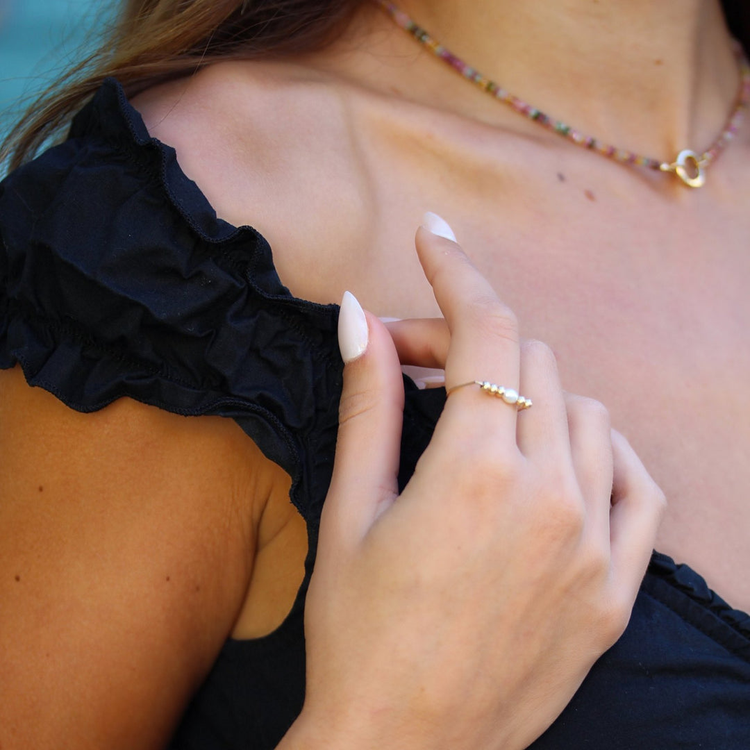 Model wearing the Beaded Pearl Remi ring, a freshwater pearl between gold filled beads, styled with the Joy tourmaline necklace