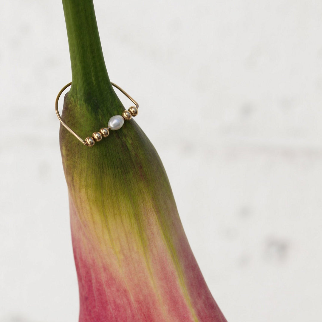 Remi ring in the Beaded Pearl style resting on a pink calla lily