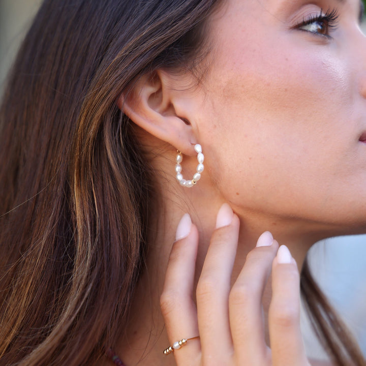 Profile of a model in Pearl Solace hoops, wearing the Beaded Pearl Remi ring