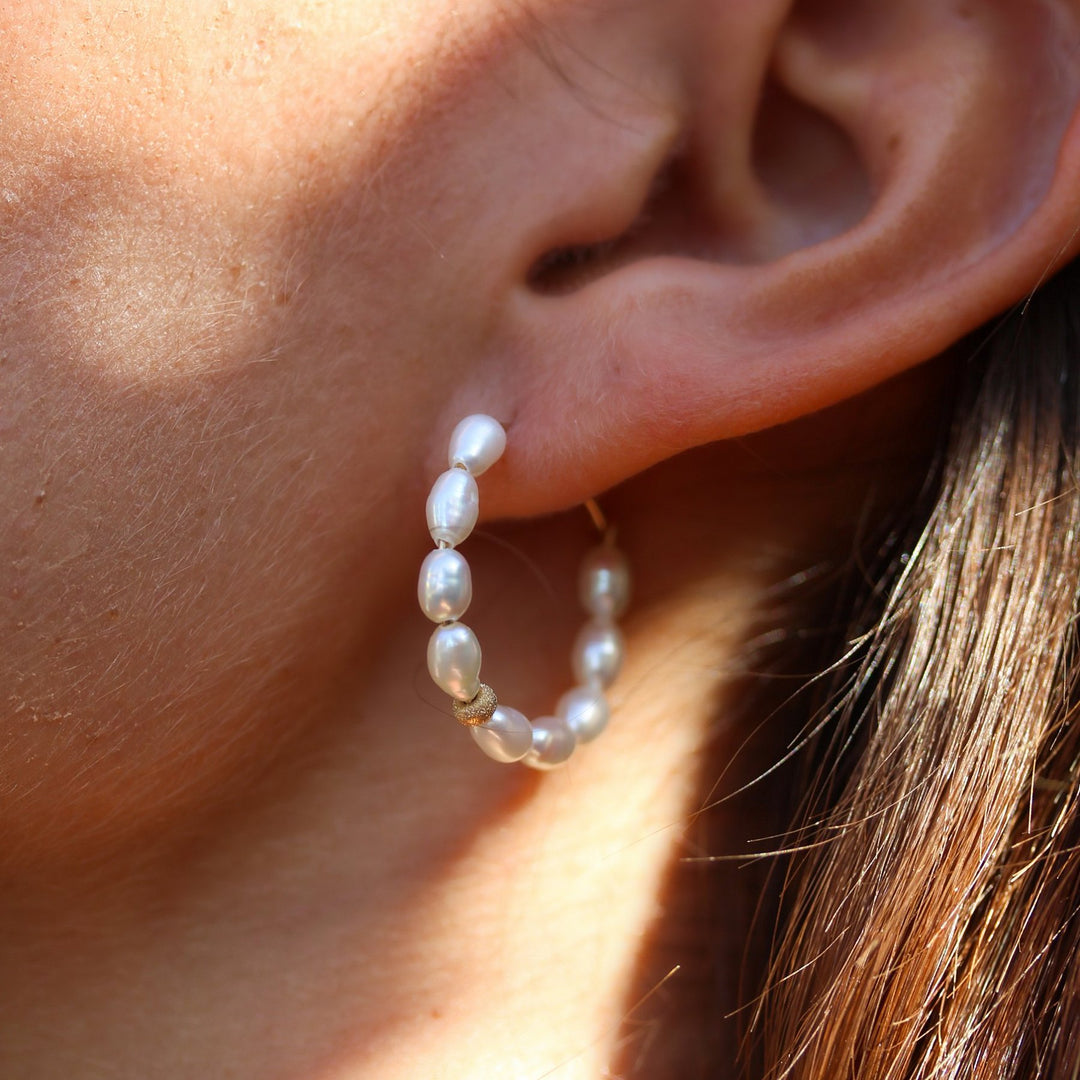 Pearl Solace hoop on the ear in warm afternoon light