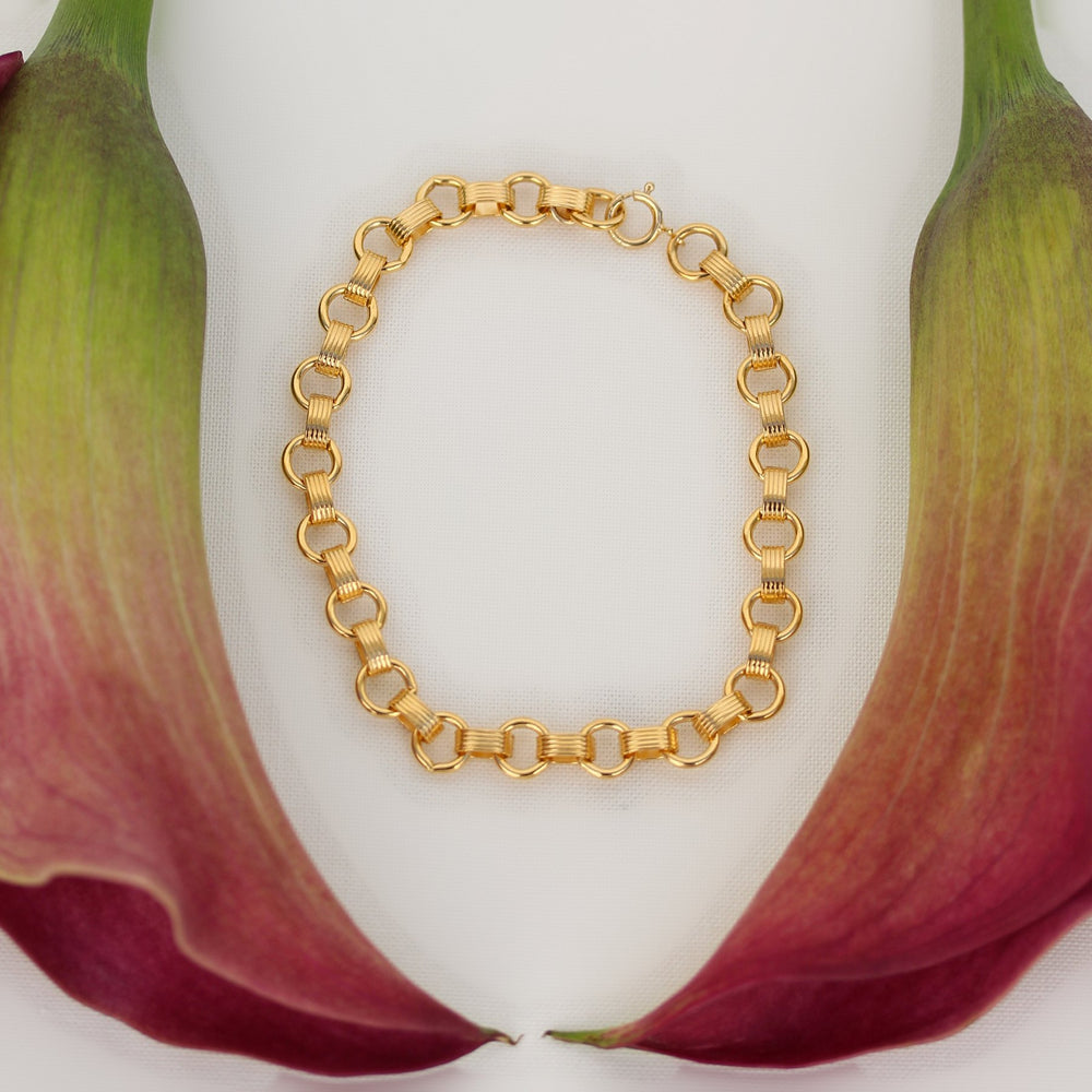 Vivienne bracelet of alternating round and ribbed gold filled links with a spring ring clasp, framed by pink calla lilies