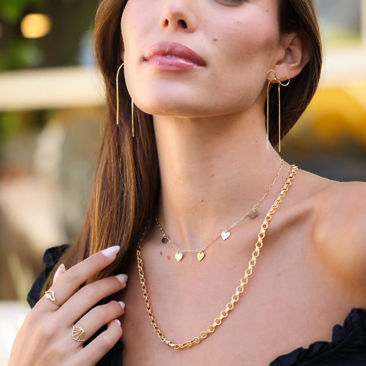 Vivienne necklace layered with the Heart charm necklace, styled with gold bow earrings