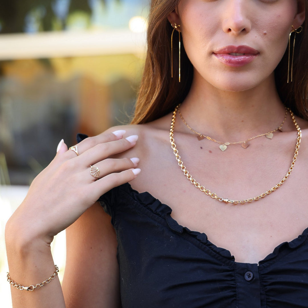 Model in a black top wearing the Vivienne chain necklace layered with the Heart necklace