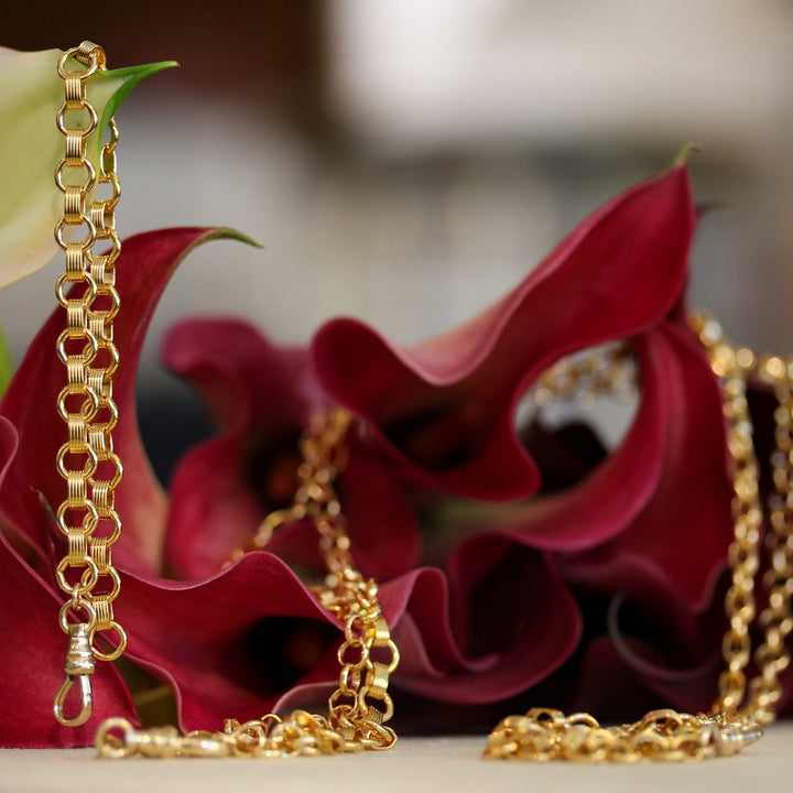 Matching Vivienne bracelet and necklace in 14k gold filled chain, shown together with burgundy calla lilies