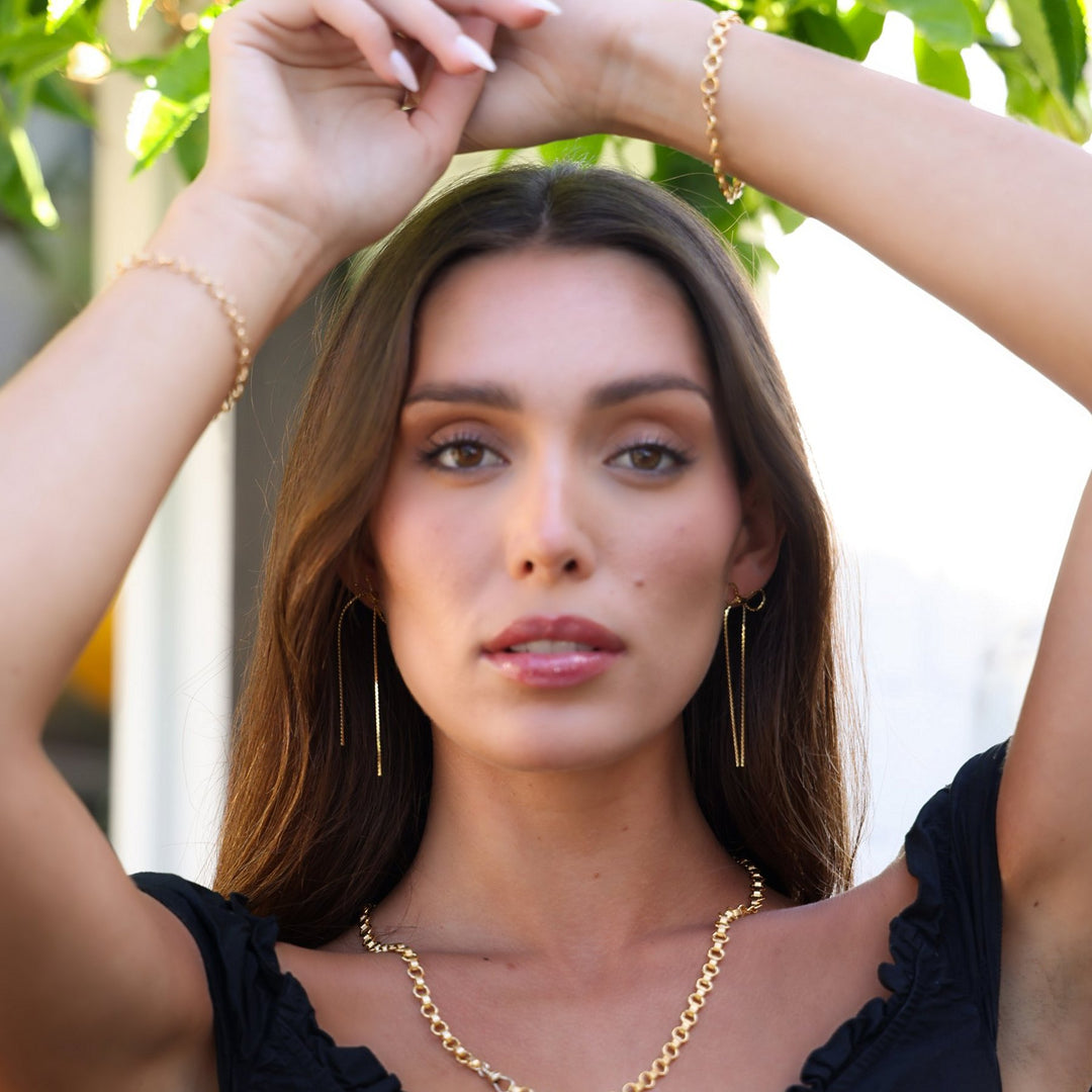 Model with arms raised wearing the Vivienne necklace and Vivienne bracelet together